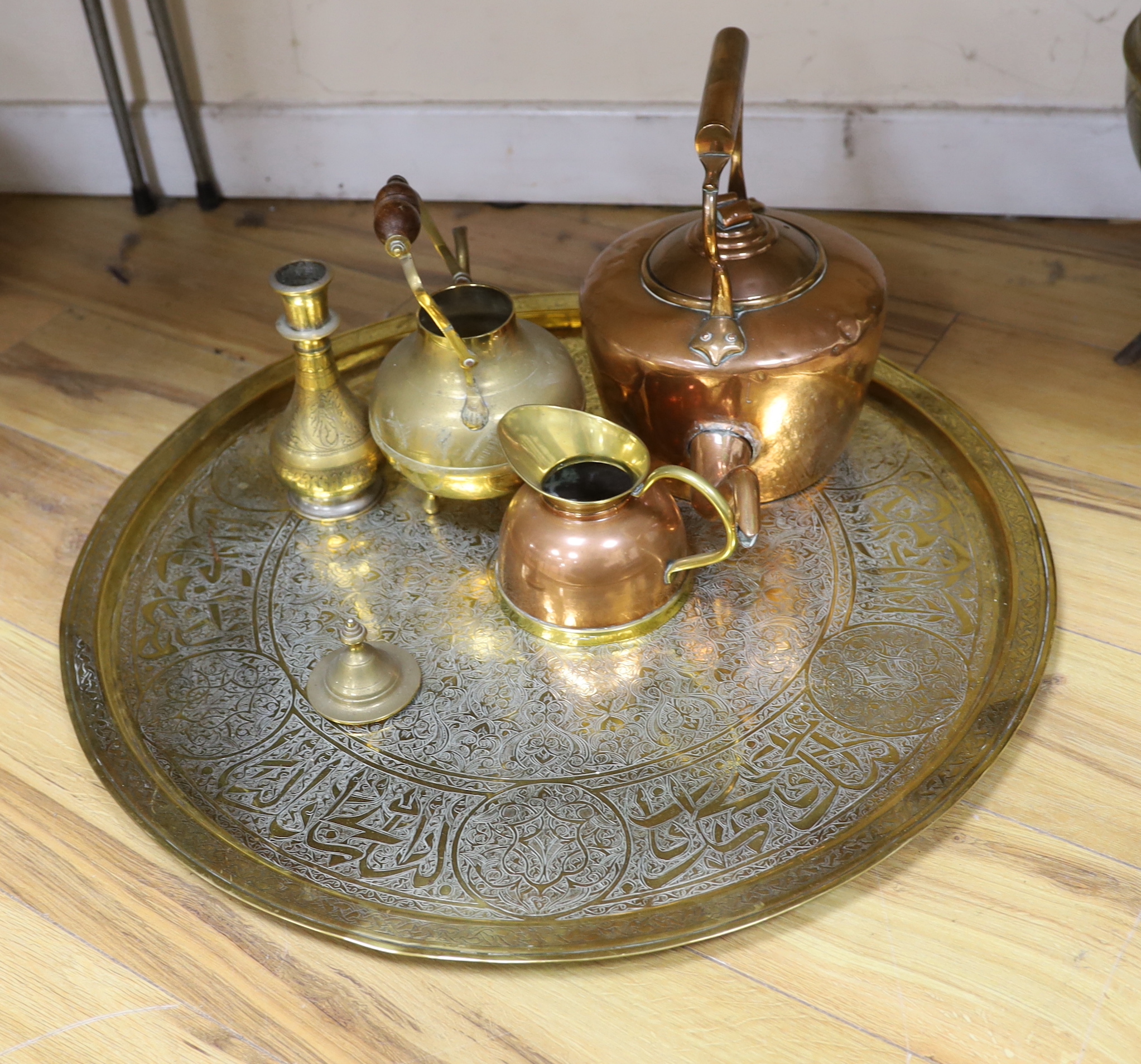 A brass cauldron shaped coal scuttle, a large circular tray, two kettles, a jug and a vase, tray 65cm diameter